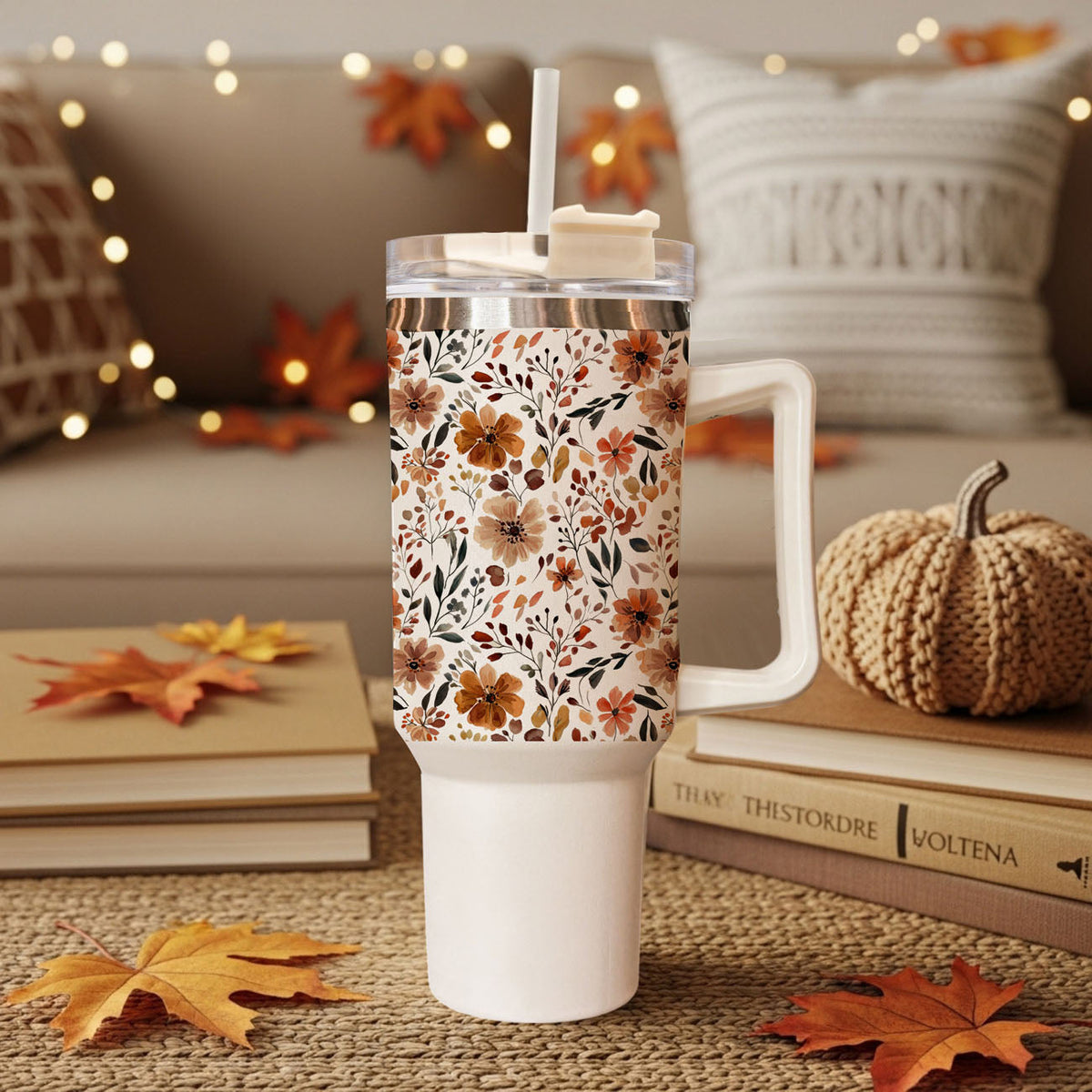 Floral 40oz tumbler with autumn flower print, clear lid and straw, on tabletop decor