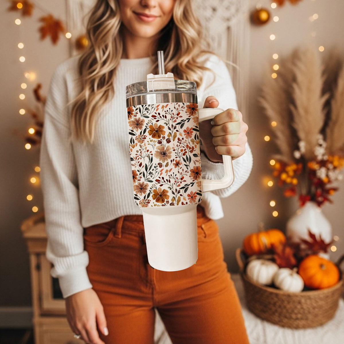 Autumn floral travel tumbler with straw and clear lid held near chest