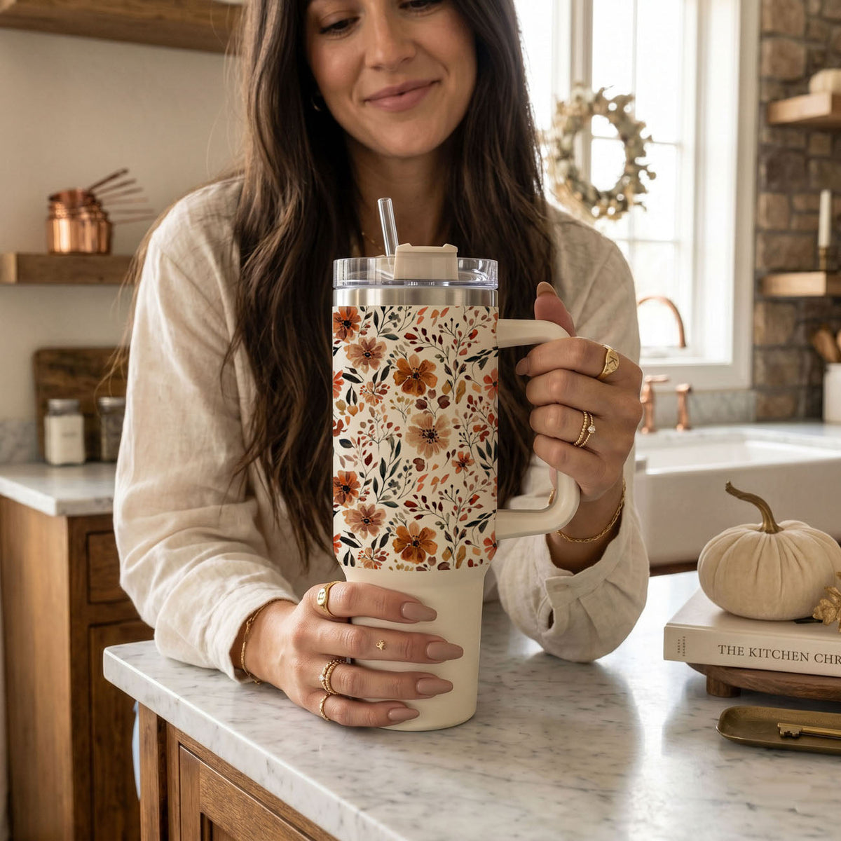 Floral 40oz tumbler with floral autumn print, clear lid and straw, held on kitchen counter