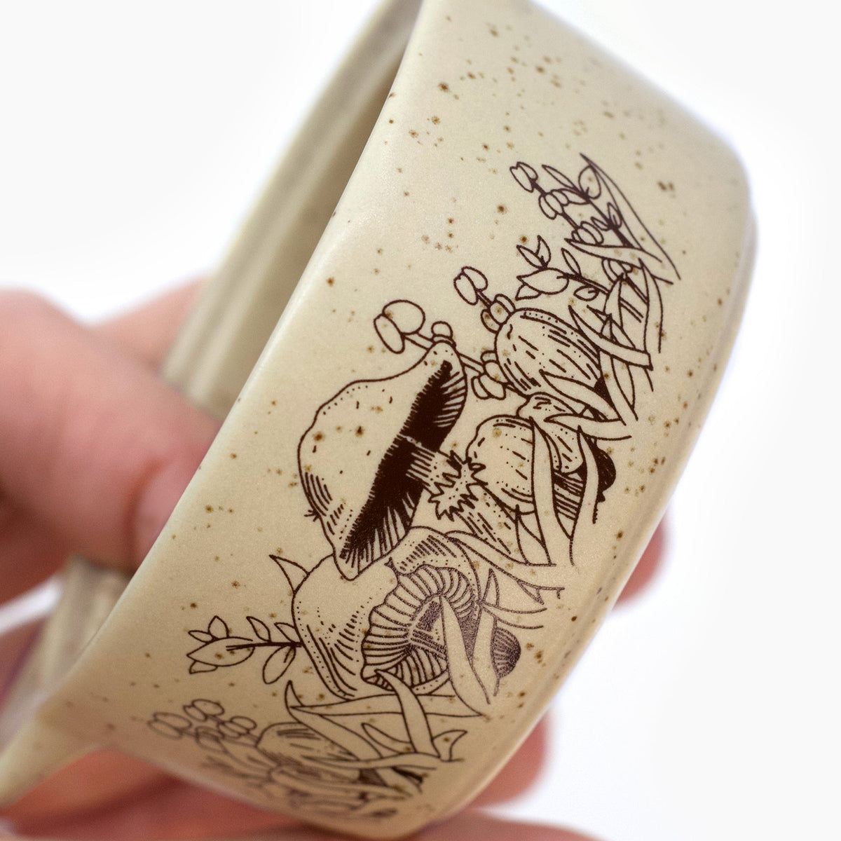 Beige ceramic trinket box close-up: forest animal illustration on side, held by hand