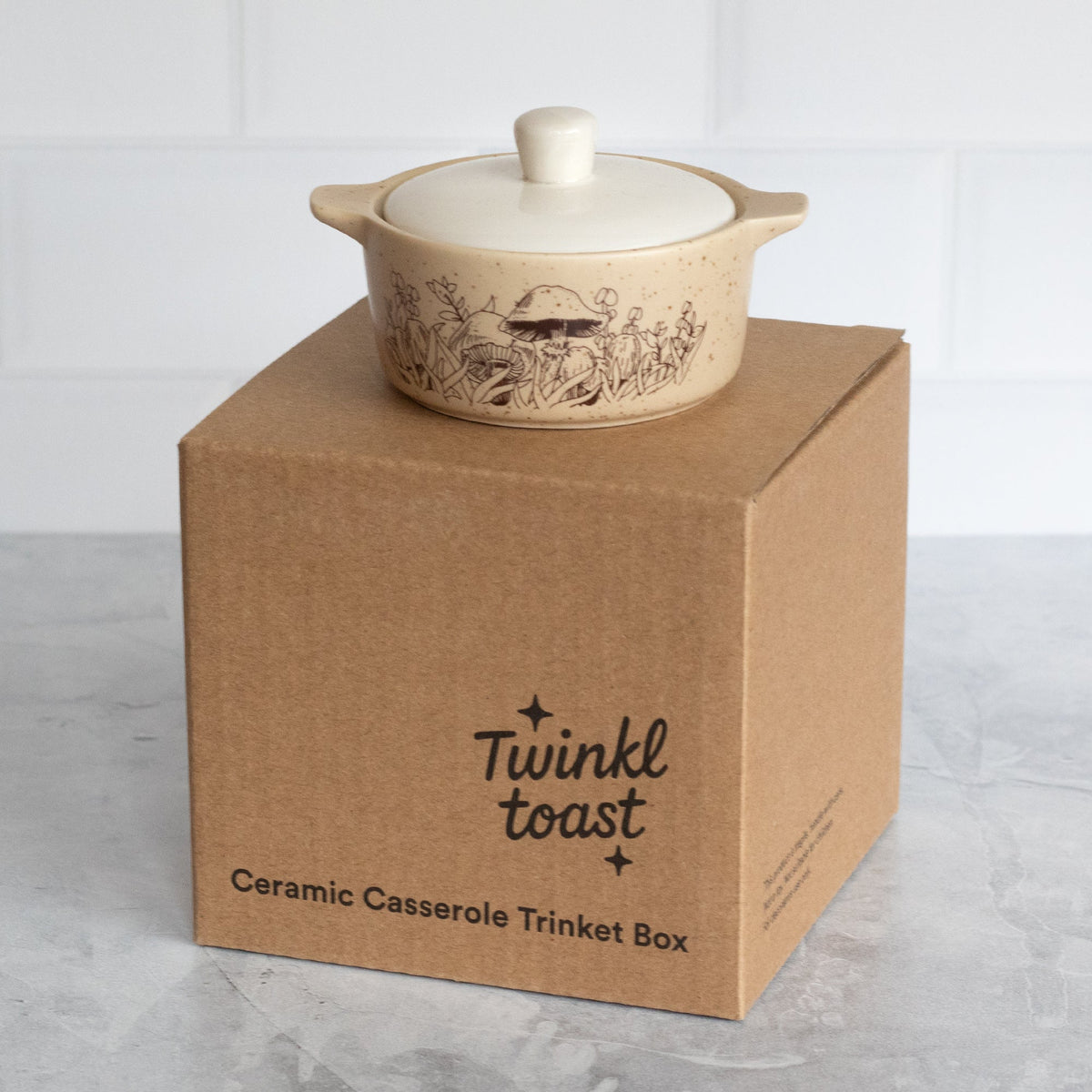 Cream ceramic casserole trinket box with lid and line art, on kraft gift box