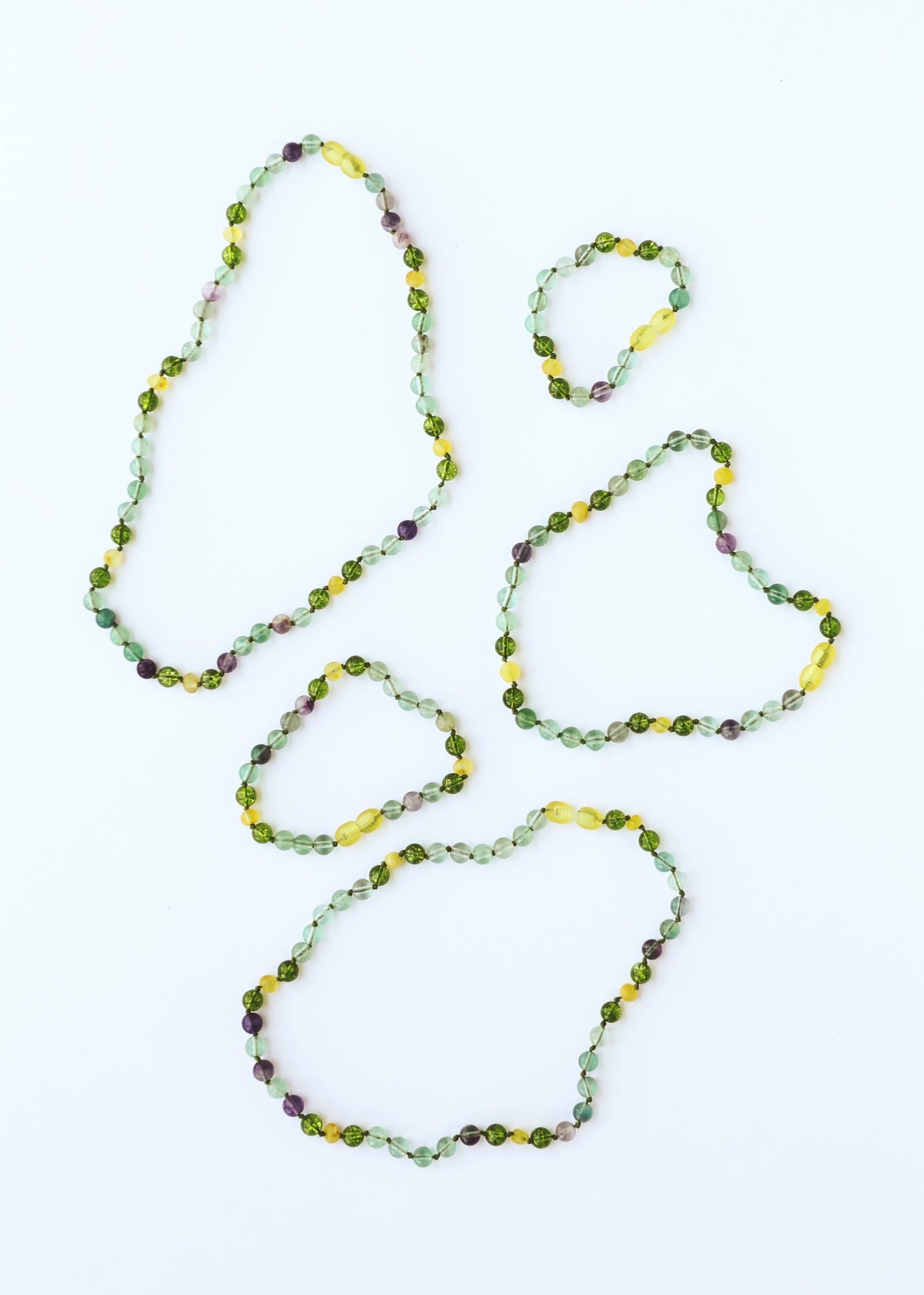 Gemstone bead necklace with layered loops, green and yellow stones with purple flecks