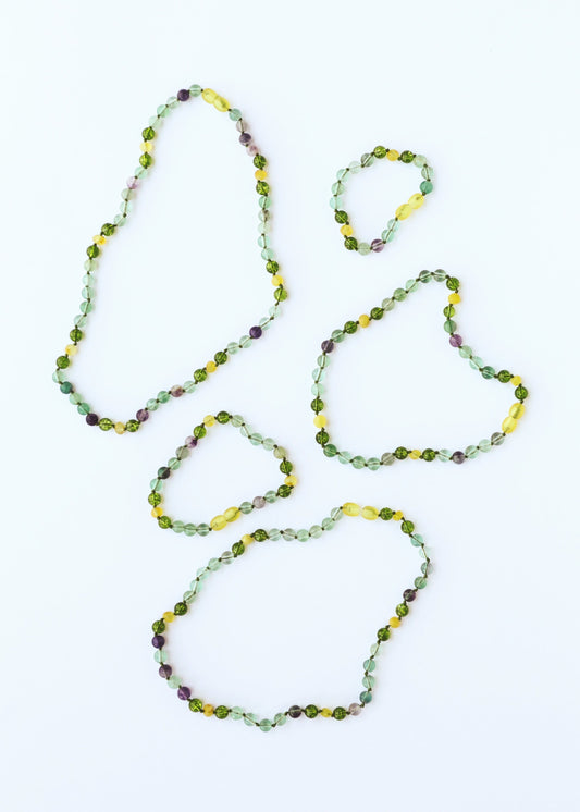 Gemstone bead necklace with layered loops, green and yellow stones with purple flecks