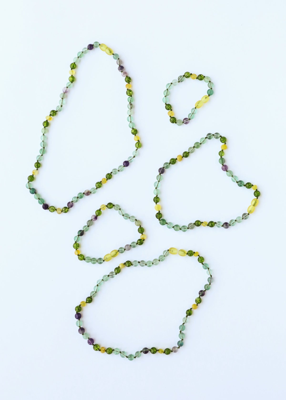 Four gemstone beaded bracelets and anklets with green, yellow, purple round faceted beads