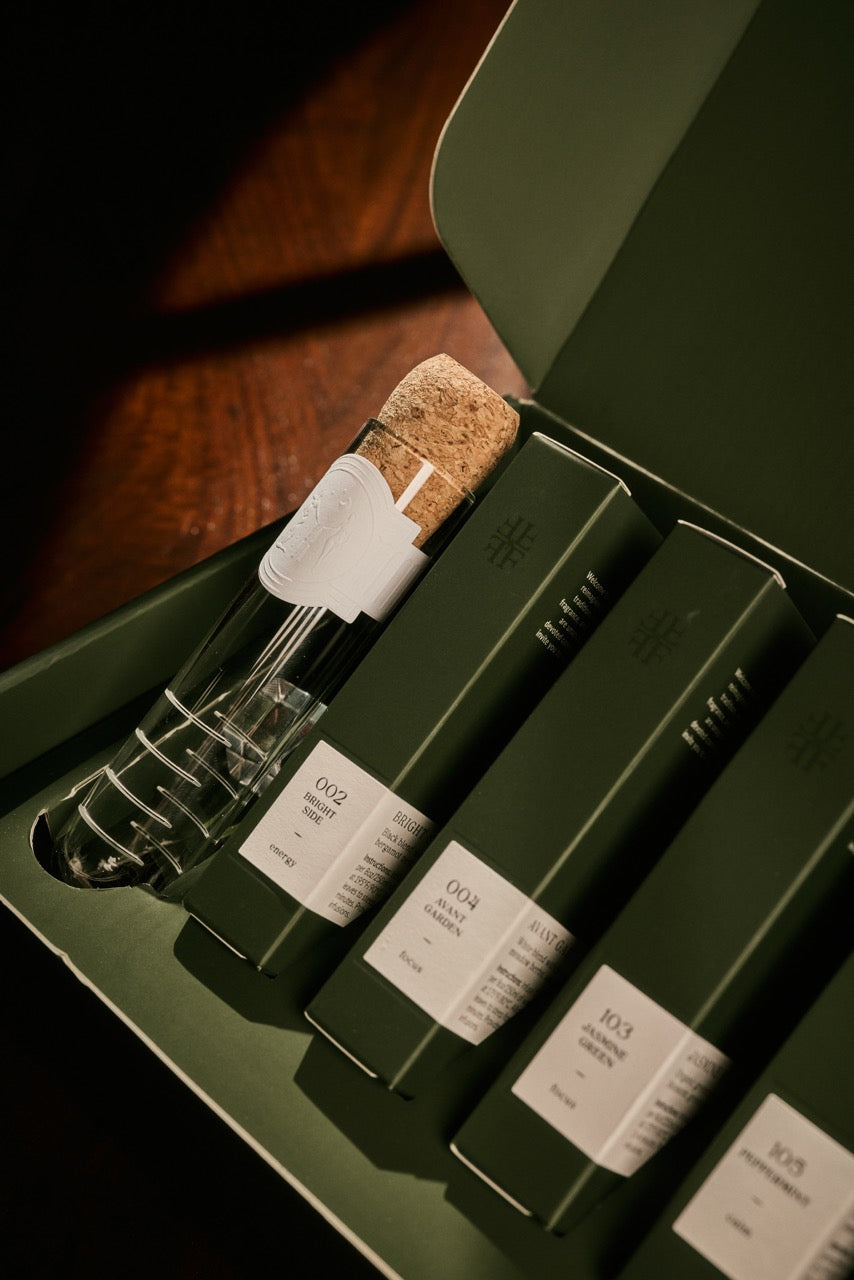 Close-up of glass vials with cork stoppers in green tray