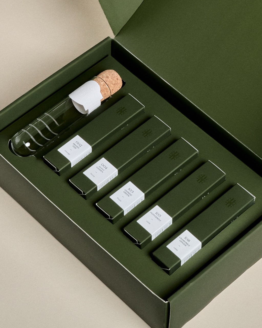 Green discovery set box with glass vials, cork stoppers, and labeled sachets