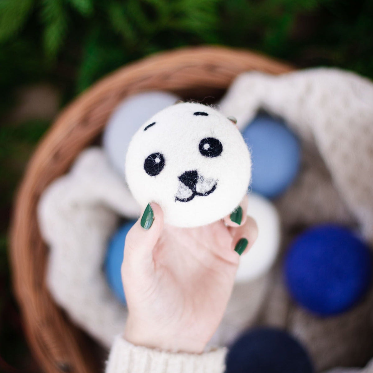 Held panda plush ball with black eyes, nose, and soft white felt face