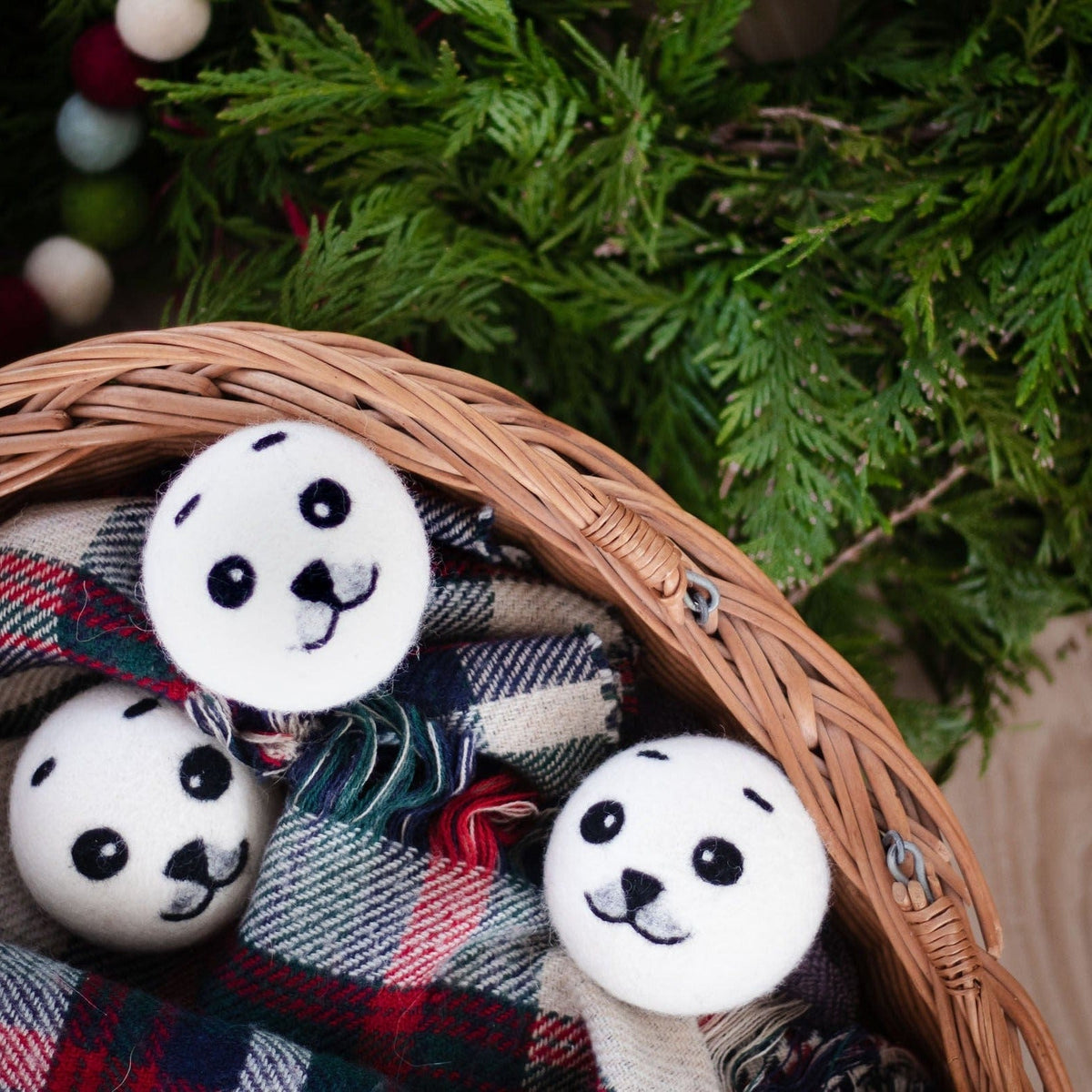 Panda plush toys in a wicker basket on plaid fabric