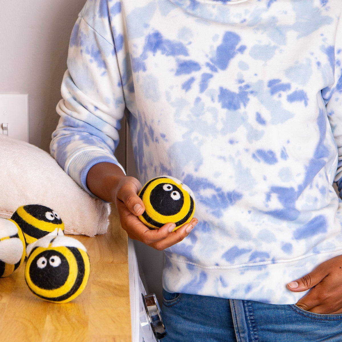 Plush bee dryer balls, yellow-and-black striped round plush held in a hand