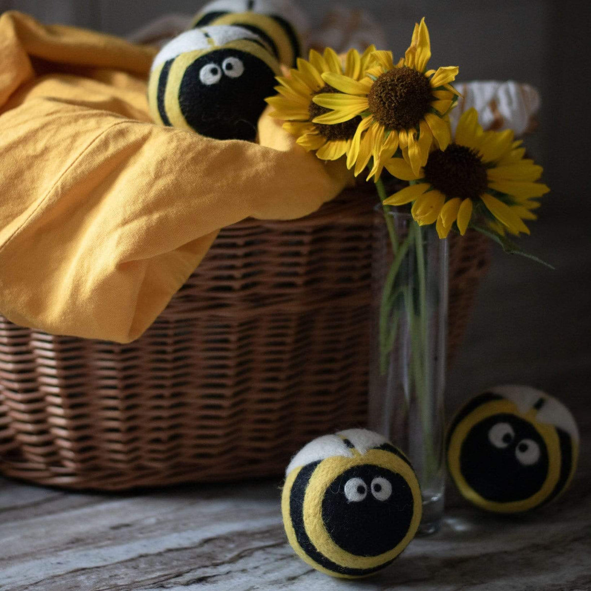 Plush bee dryer balls with yellow-and-black striped design and big white eyes