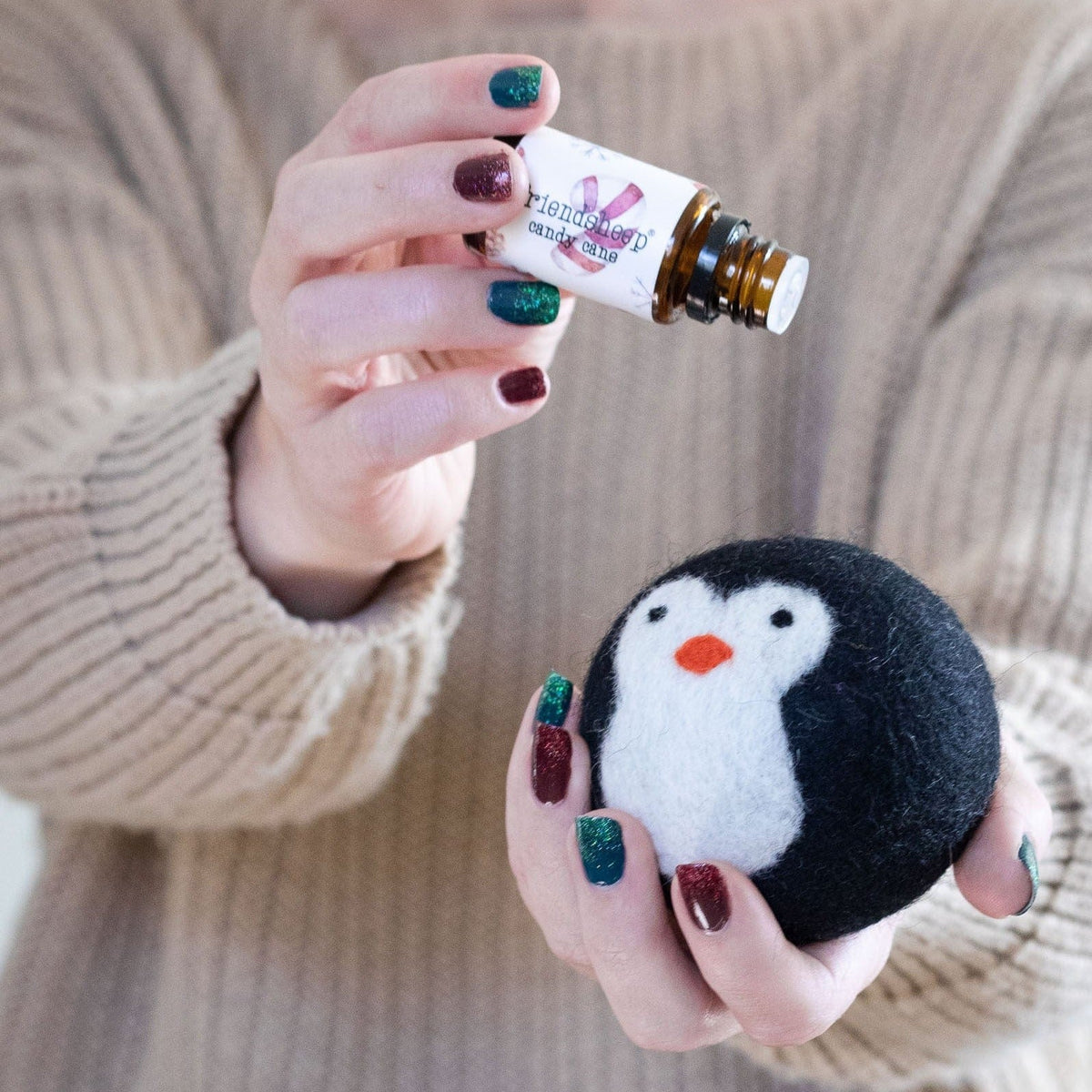 Black-and-white penguin plush toy held in hands, plush face visible