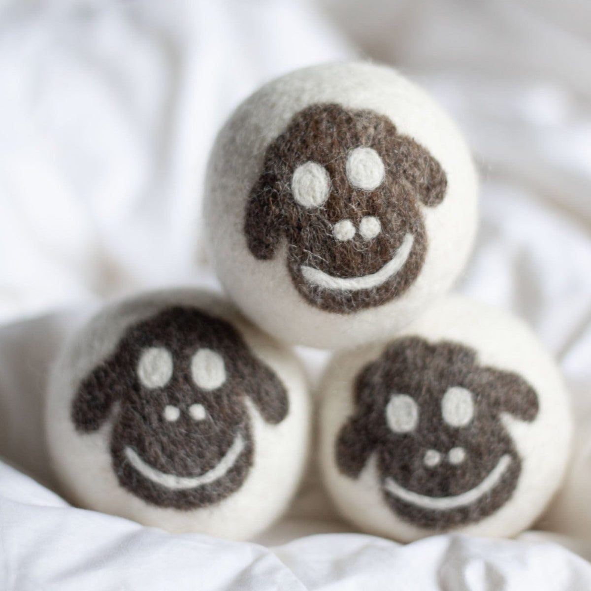 Felt wool sheep dryer balls, three-pack with smiling faces and paw details