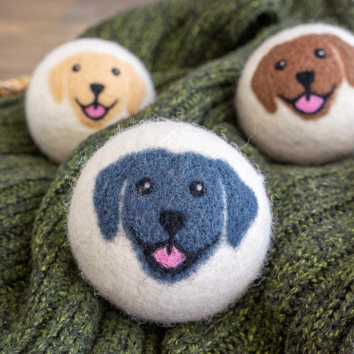 Blue felt dog-face button on green knit, with three other buttons behind.