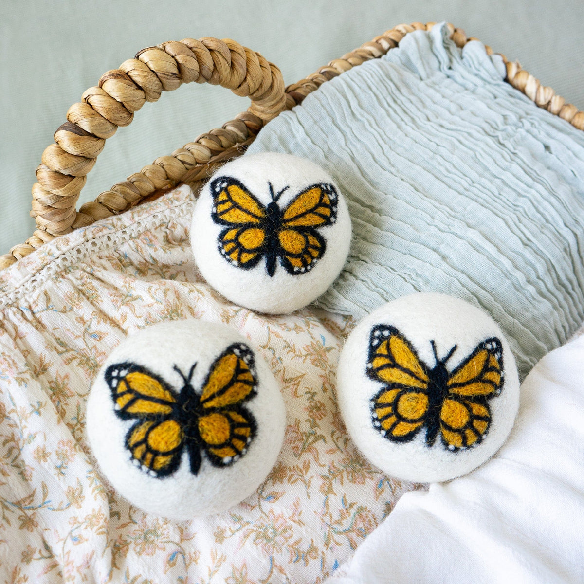 Monarch butterfly felt ball trio on quilted fabric with curved rope handles