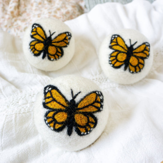 Monarch butterfly plush felt balls, three with detailed yellow-and-black butterfly embroidery