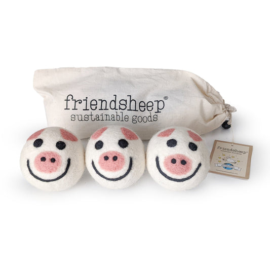Three round pig plush toys with embroidered faces and pink snouts in a fabric pouch