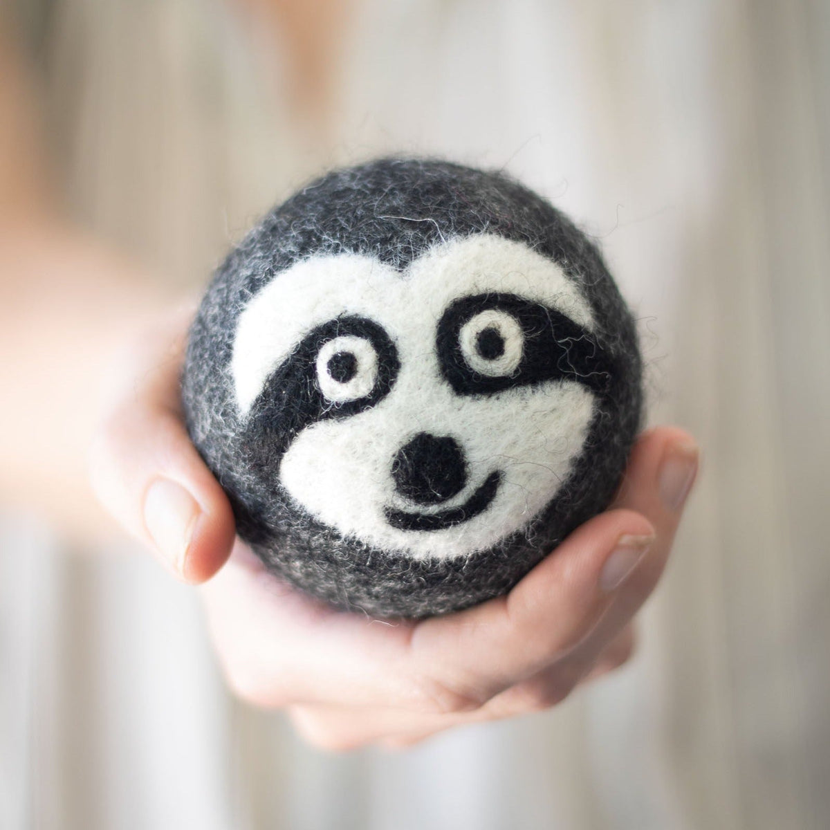 Single felt sloth dryer ball with embroidered smiling face