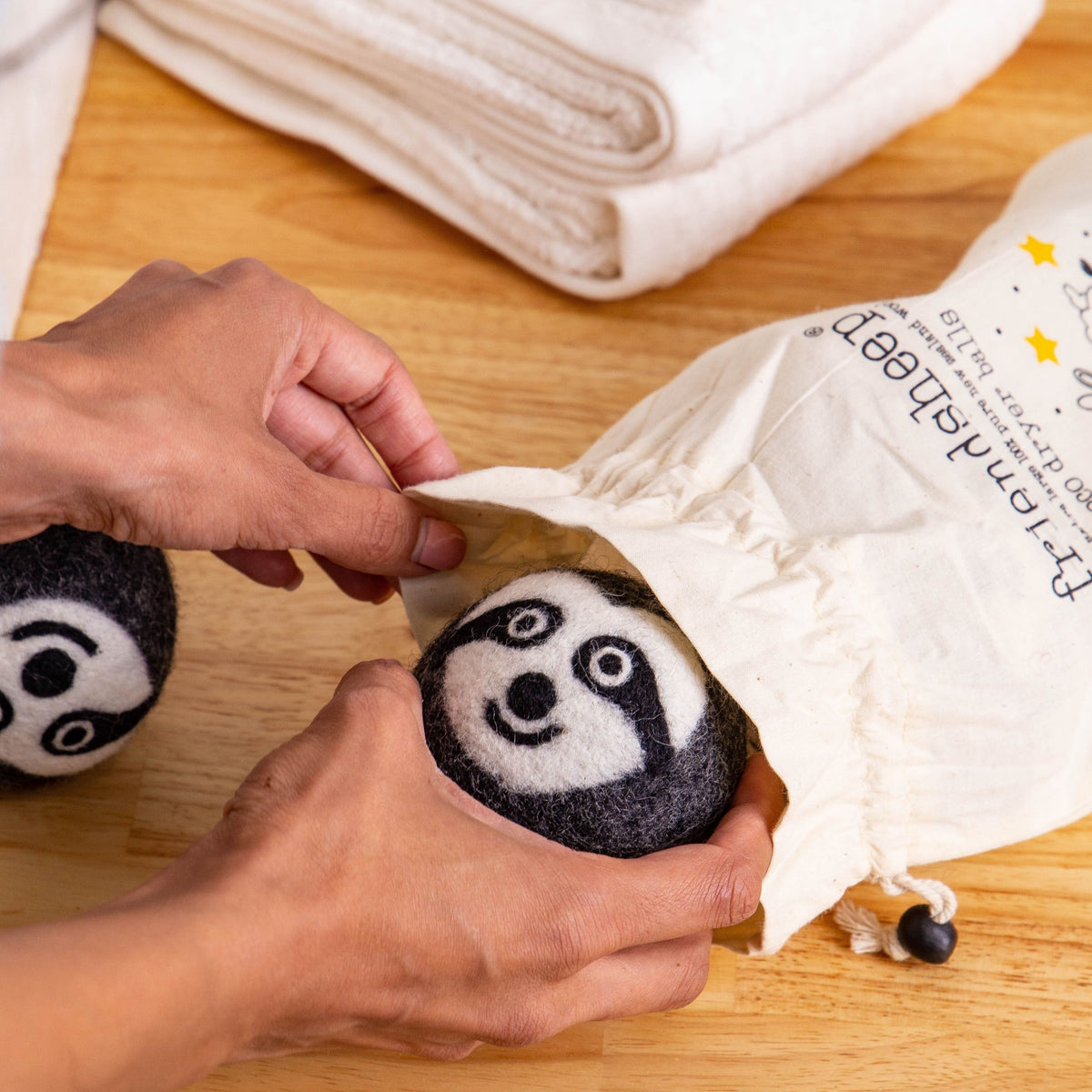 Felt sloth dryer balls removed from a fabric pouch