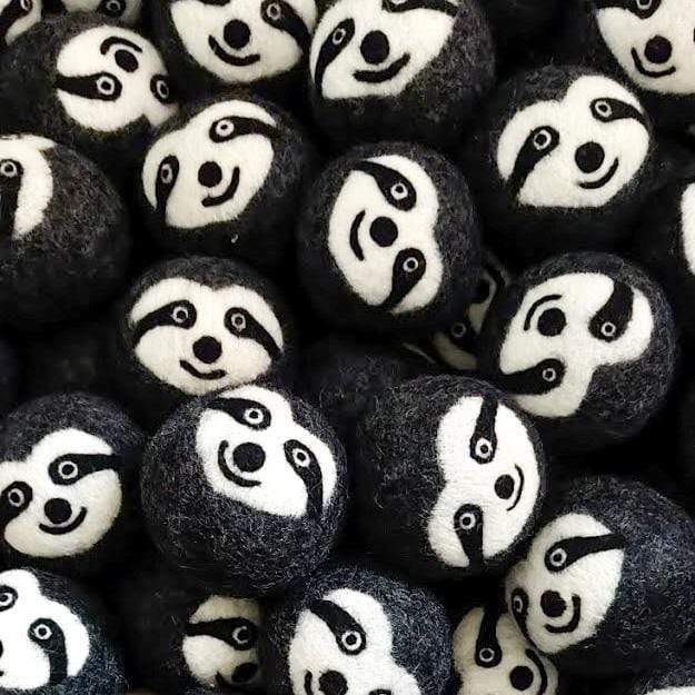 Close-up of felt sloth dryer balls with embroidered faces