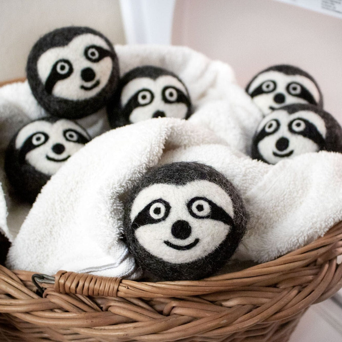 Felt sloth plush trio in a wicker basket with one sloth centered