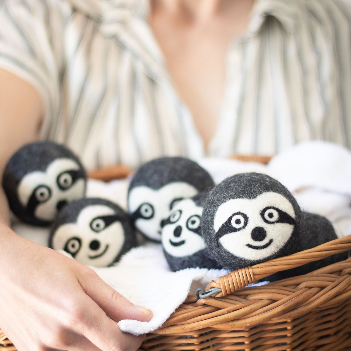 Felt sloth plush trio in a wicker basket with soft white backing