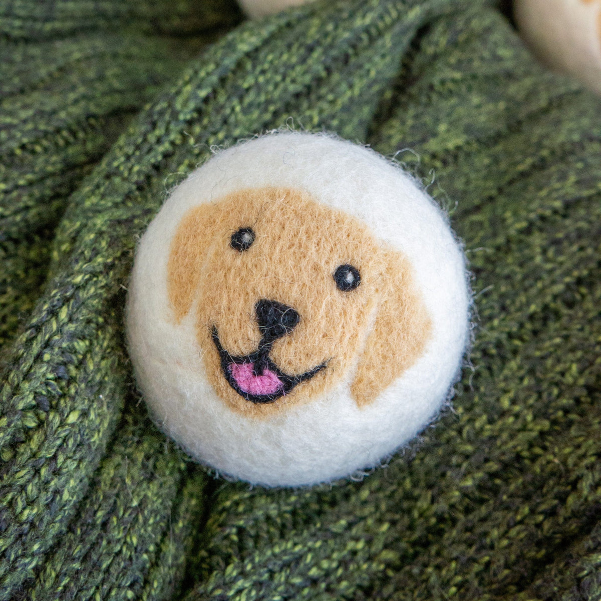Plush dog face patch on textured green knit fabric