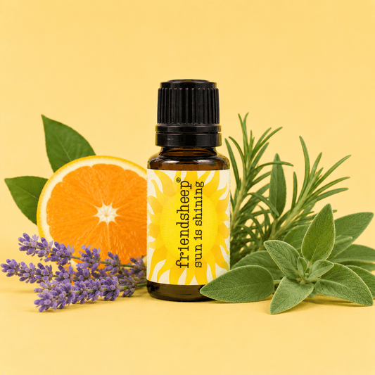 Amber essential oil blend bottle with black cap beside orange, lavender, and green leaves.