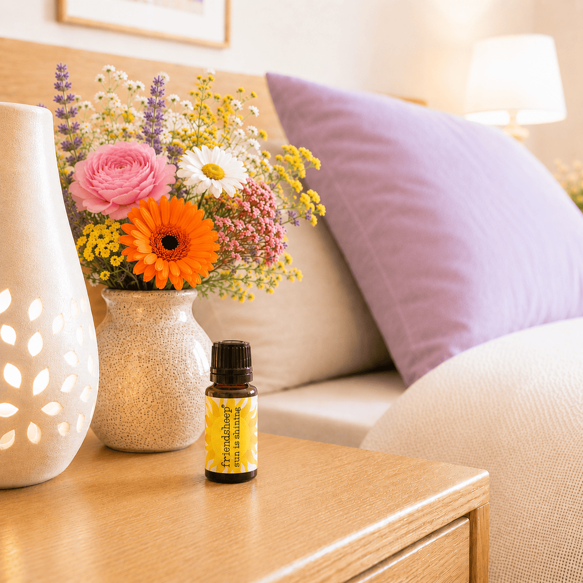 Amber essential oil blend bottle with black cap on wooden table near a flower bouquet.