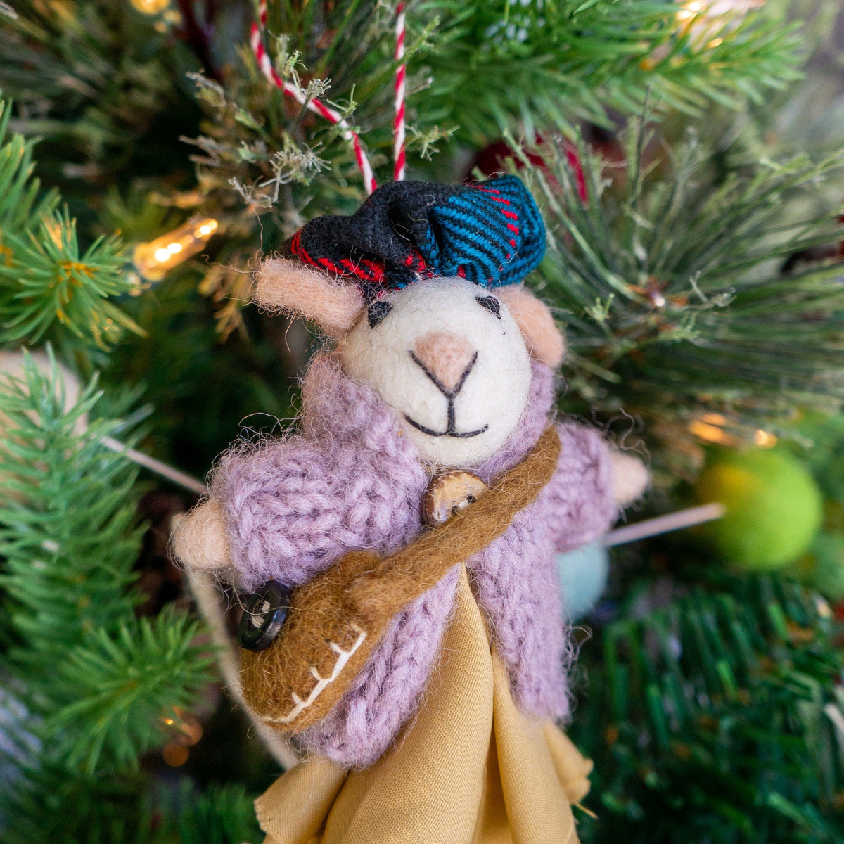 Felt mouse ornament with plaid scarf and knitted blue pants on a pine branch