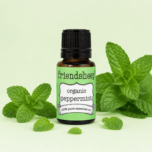 Organic peppermint essential oil bottle with mint leaves, green label, black cap