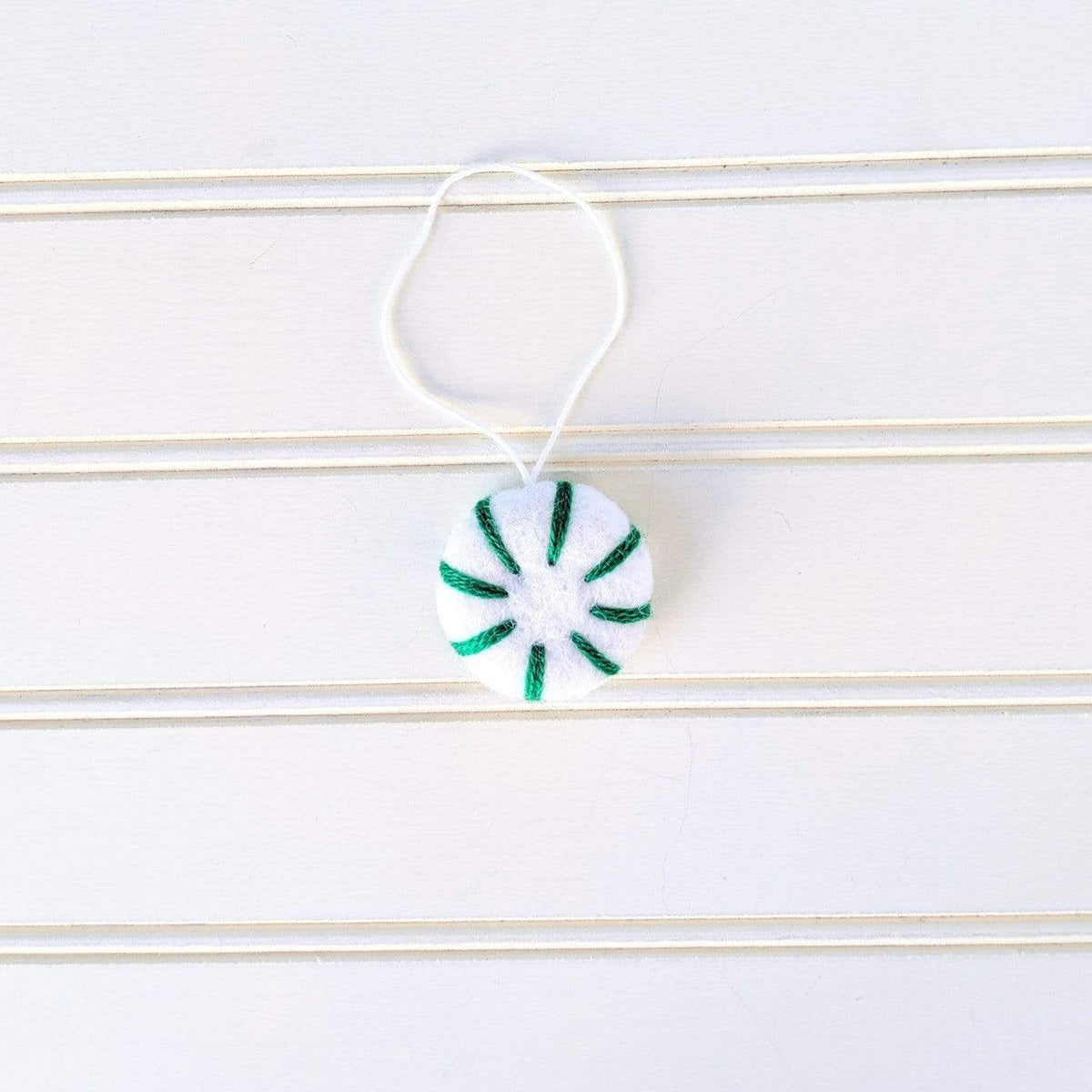 Green-and-white felt peppermint swirl eco freshener ornament hanging by white cord
