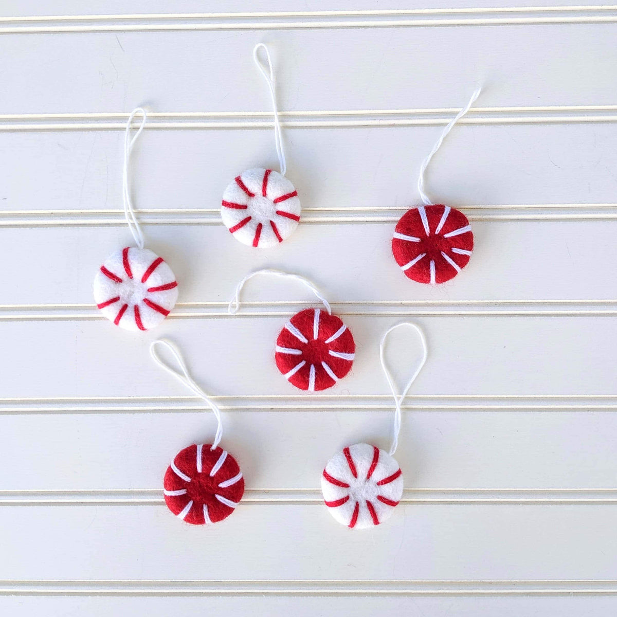 Set of red and white felt peppermint ornament fresheners on hanging strings