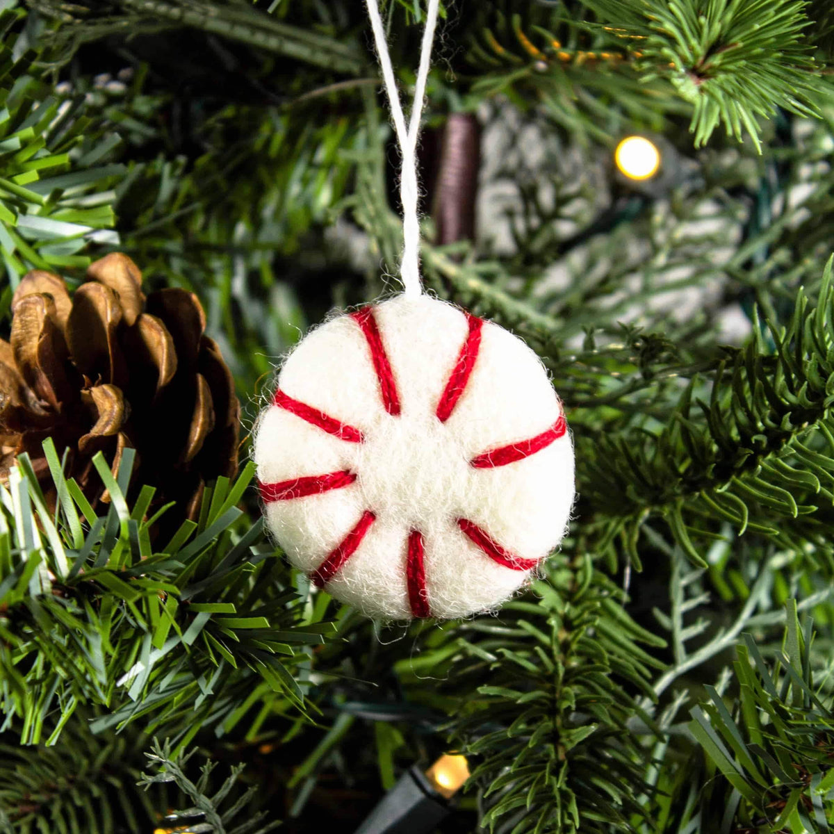 Red-and-white felt peppermint ornament freshener hanging on a Christmas tree