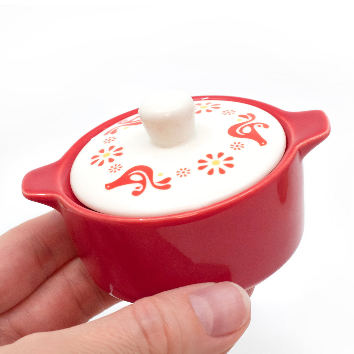 Red ceramic casserole trinket box with white lid and knob, red floral and swirl motifs.