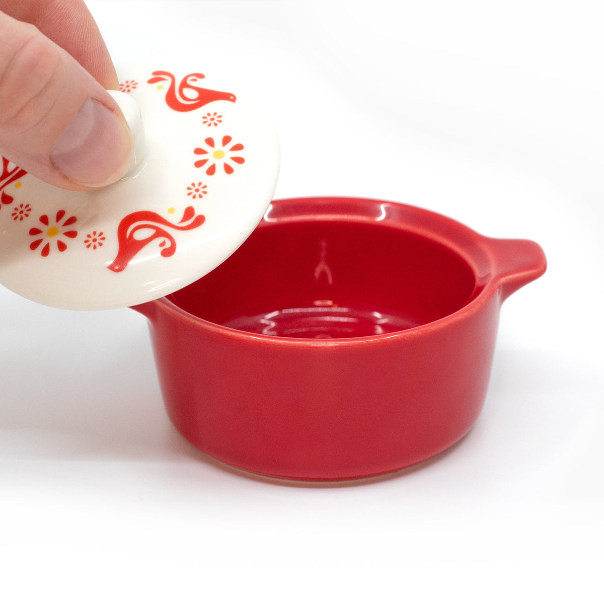 Red ceramic casserole trinket box with open white lid; red motif visible on lid top.