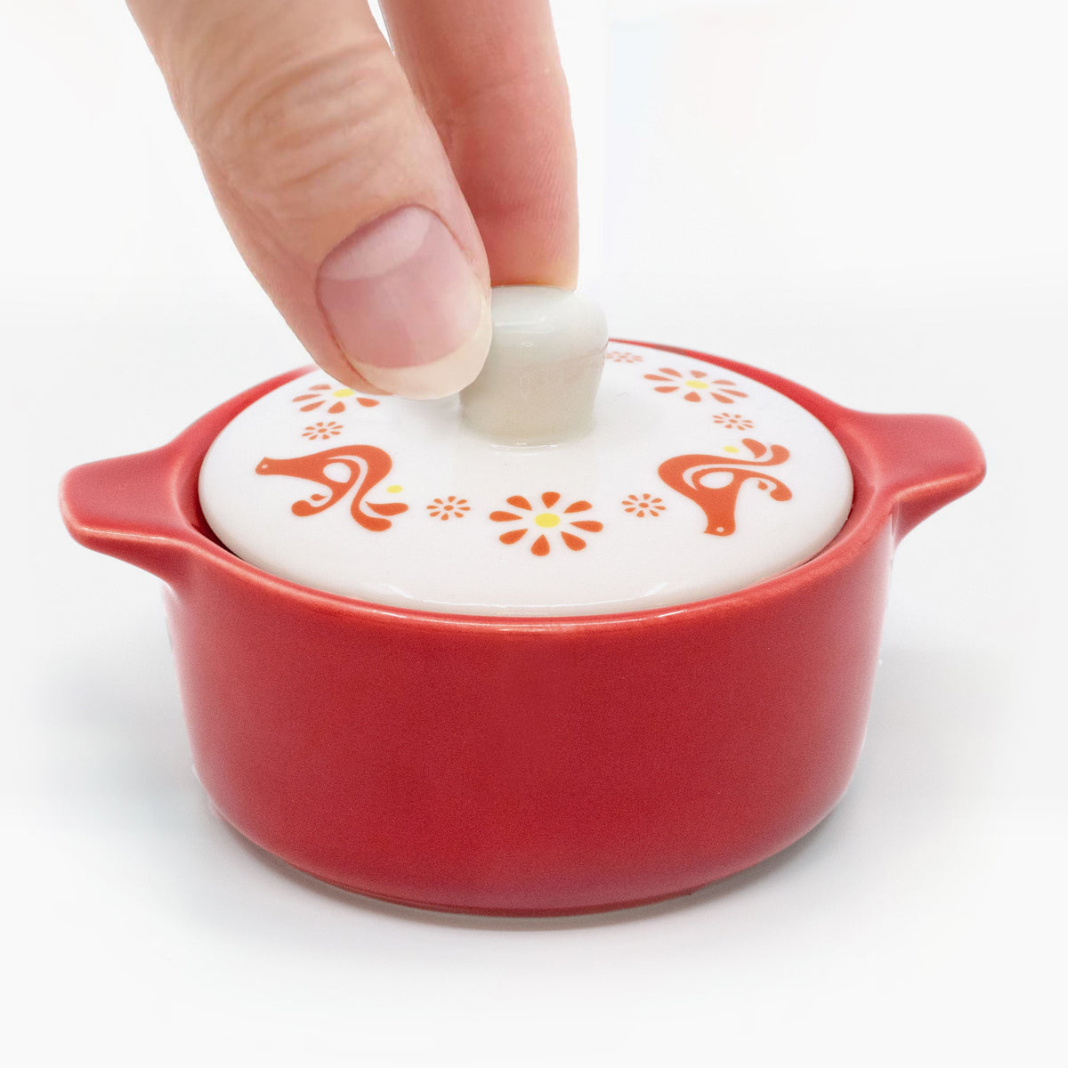 Red ceramic casserole trinket box with white lid, red decorative motifs; lid knob shown.