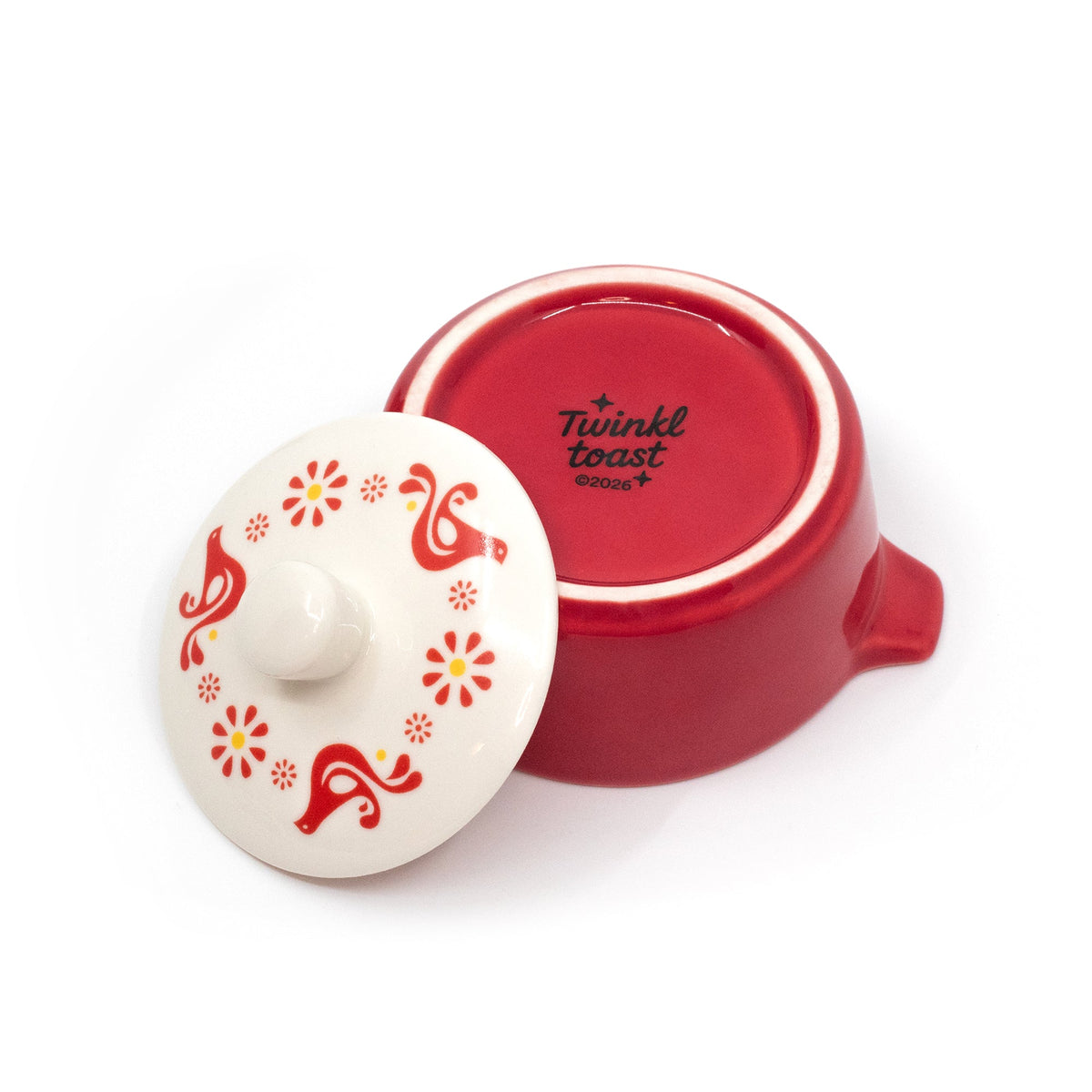Red ceramic casserole trinket box with lid open; gold-tone text shows on base underside.