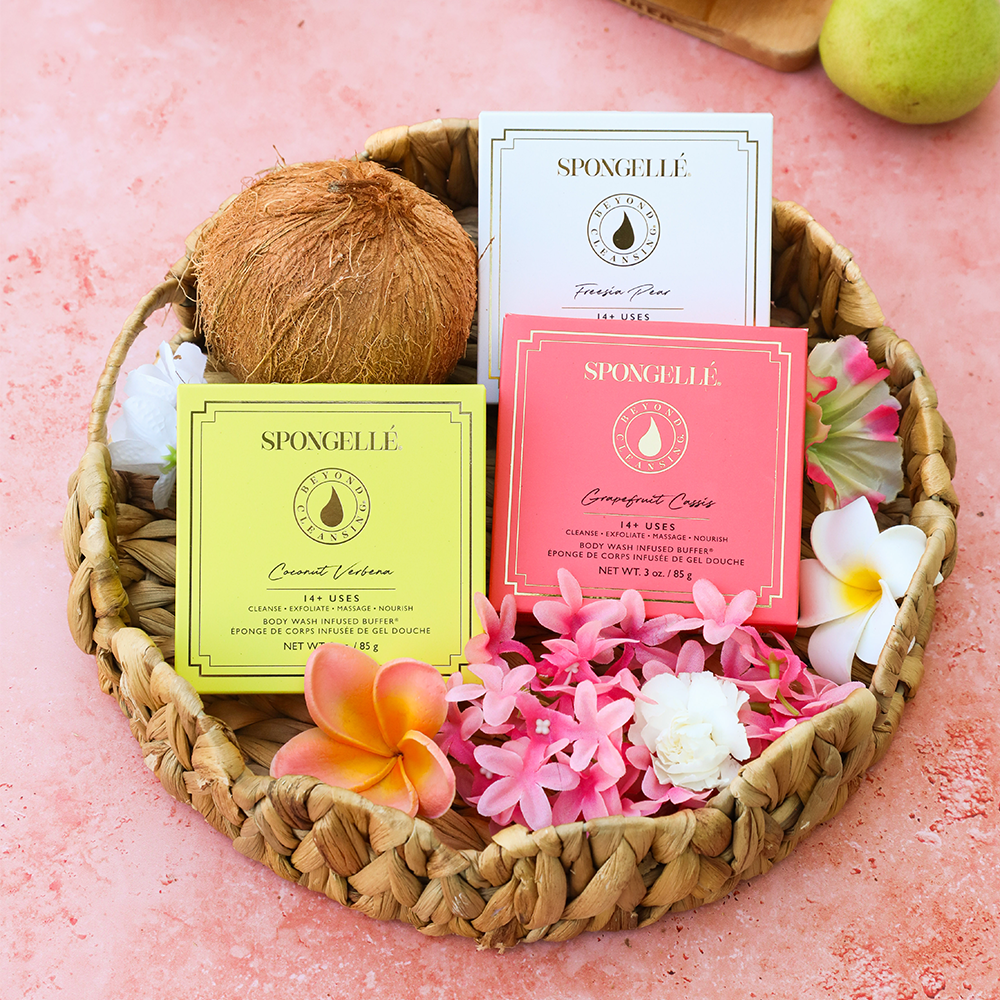 Boxed flower cleanser set in a woven tray with three colored SPONGELLE boxes and petals