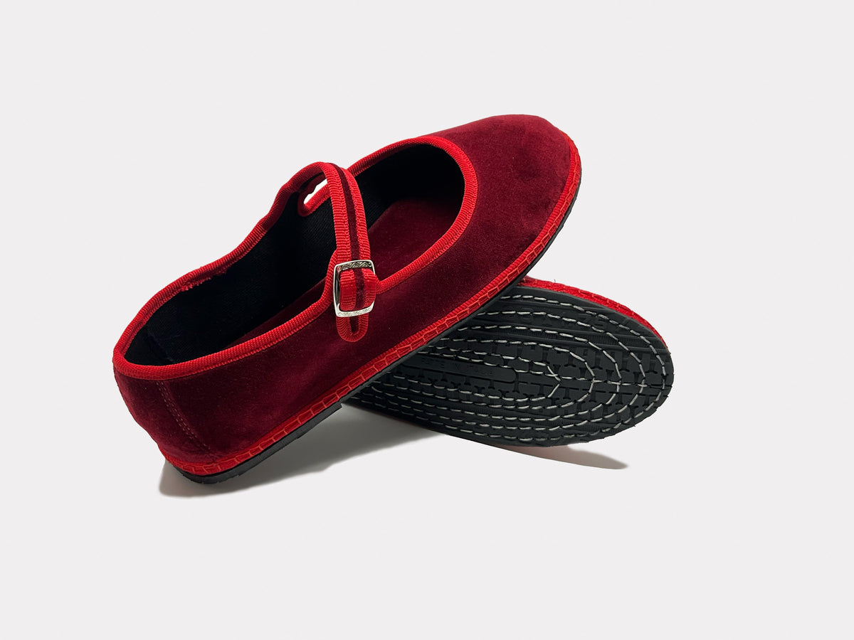 Burgundy Mary Jane flats with strap buckle and visible textured outsole