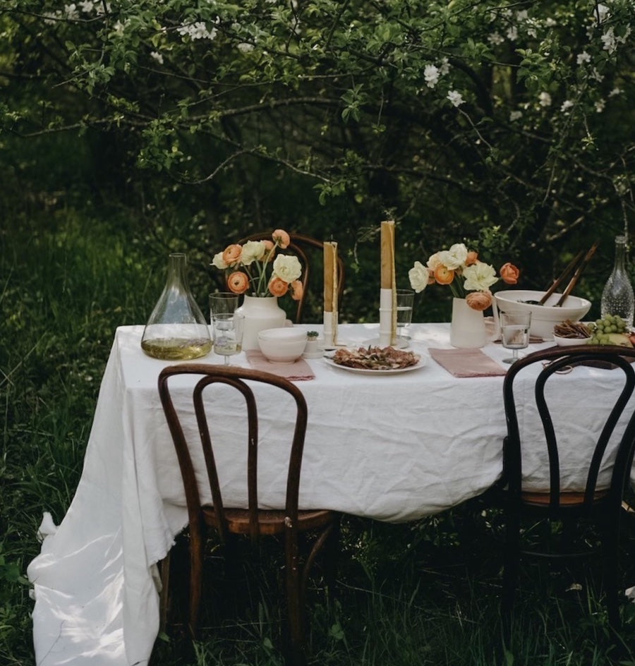 White linen tablecloth draped over an outdoor dining table