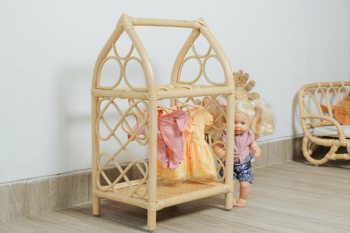 Natural rattan doll clothes rack with decorative woven sides and miniature clothes on hangers