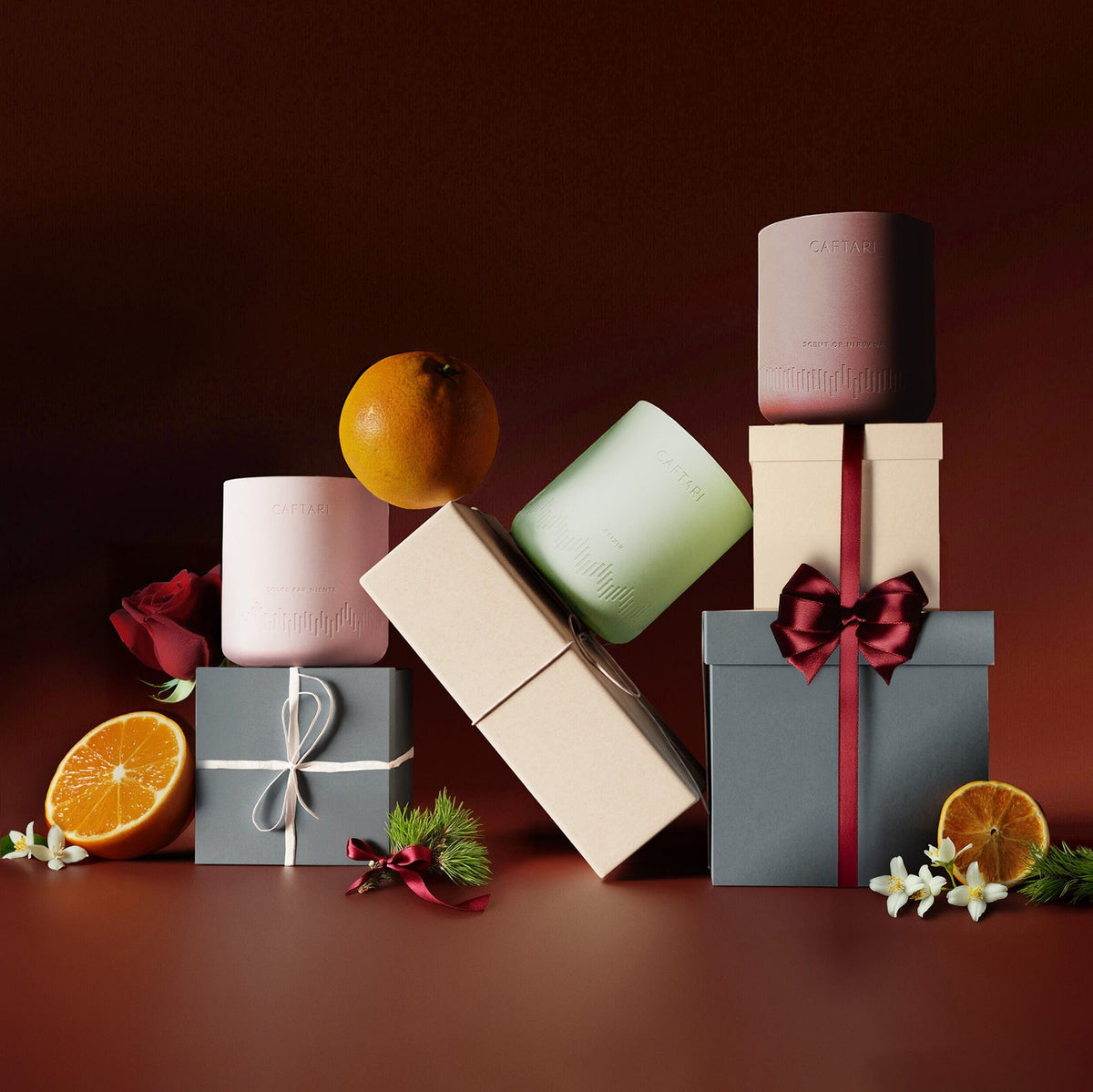 Signature gift set candles with a wrapped gift box and red ribbon, plus citrus flowers