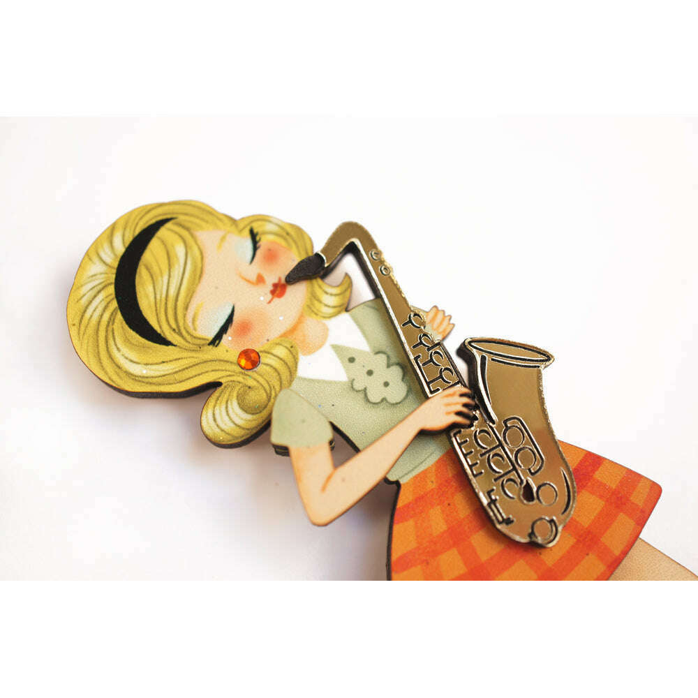Girl playing saxophone brooch close-up, yellow hair, green top, orange skirt, sax detail.