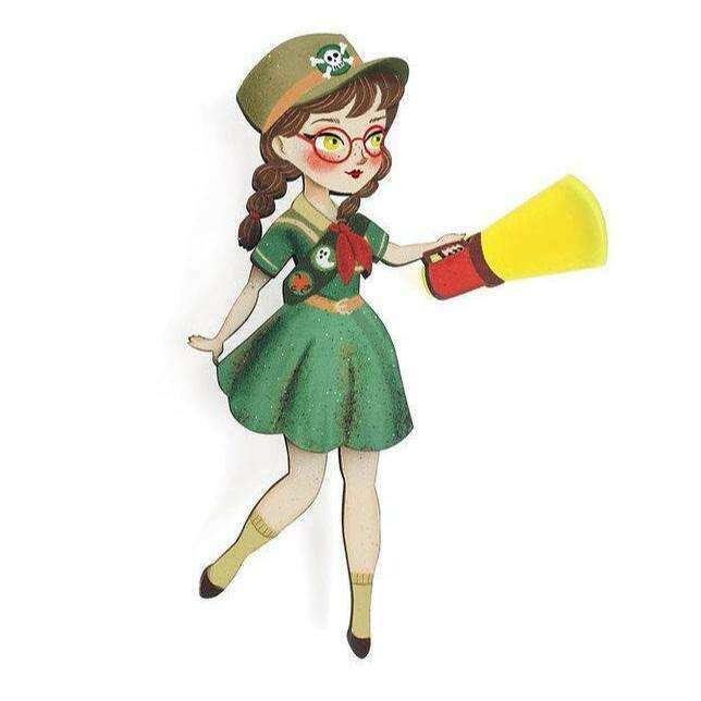 Girl Scout-themed enamel brooch of a cartoon scout girl with green dress and hat
