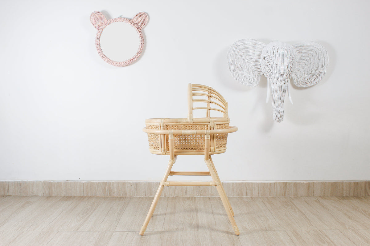 Pink rattan teddy bear wall mirror beside a white woven elephant wall hanging
