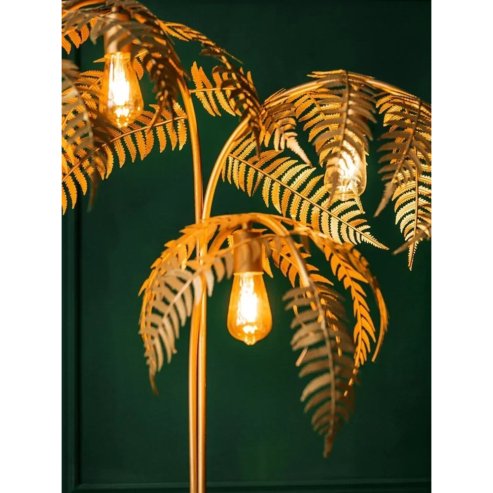 Gold palm tree floor lamp with three illuminated fronds