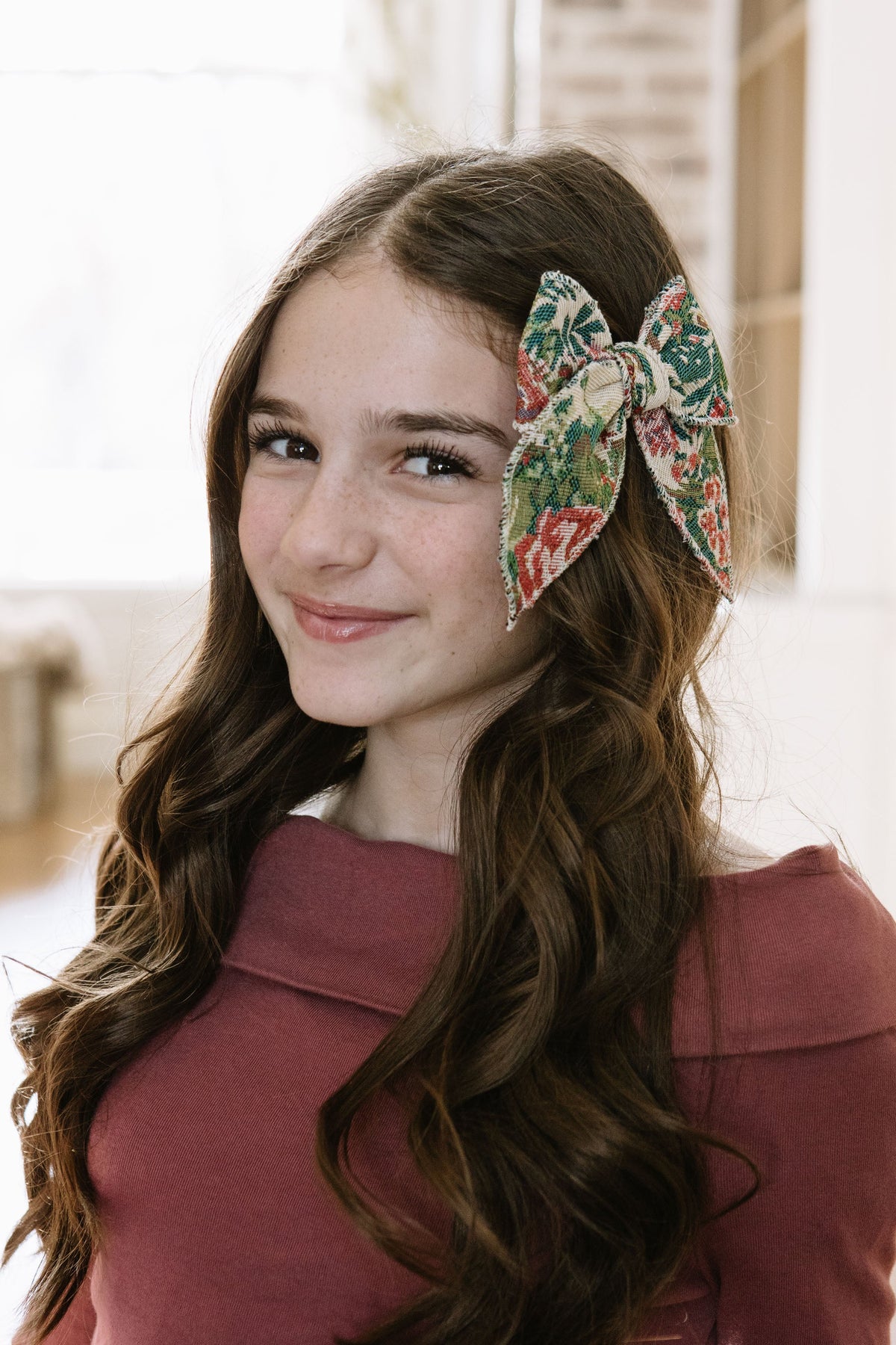 Green and red plaid hair bow with cream trim, worn on side