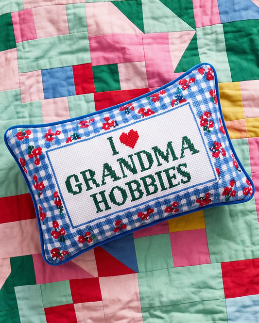 Needlepoint throw pillow with blue gingham floral trim and “I ♥ Grandma Hobbies” lettering