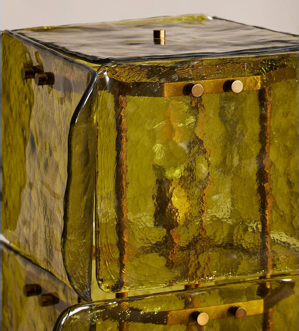 Close-up of textured green glass panel edges and metal fasteners