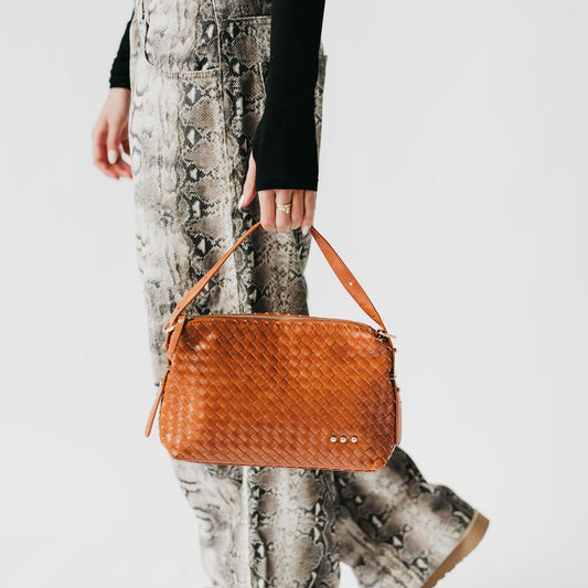 Woven hobo shoulder bag in brown with top zip and braided leather strap ends